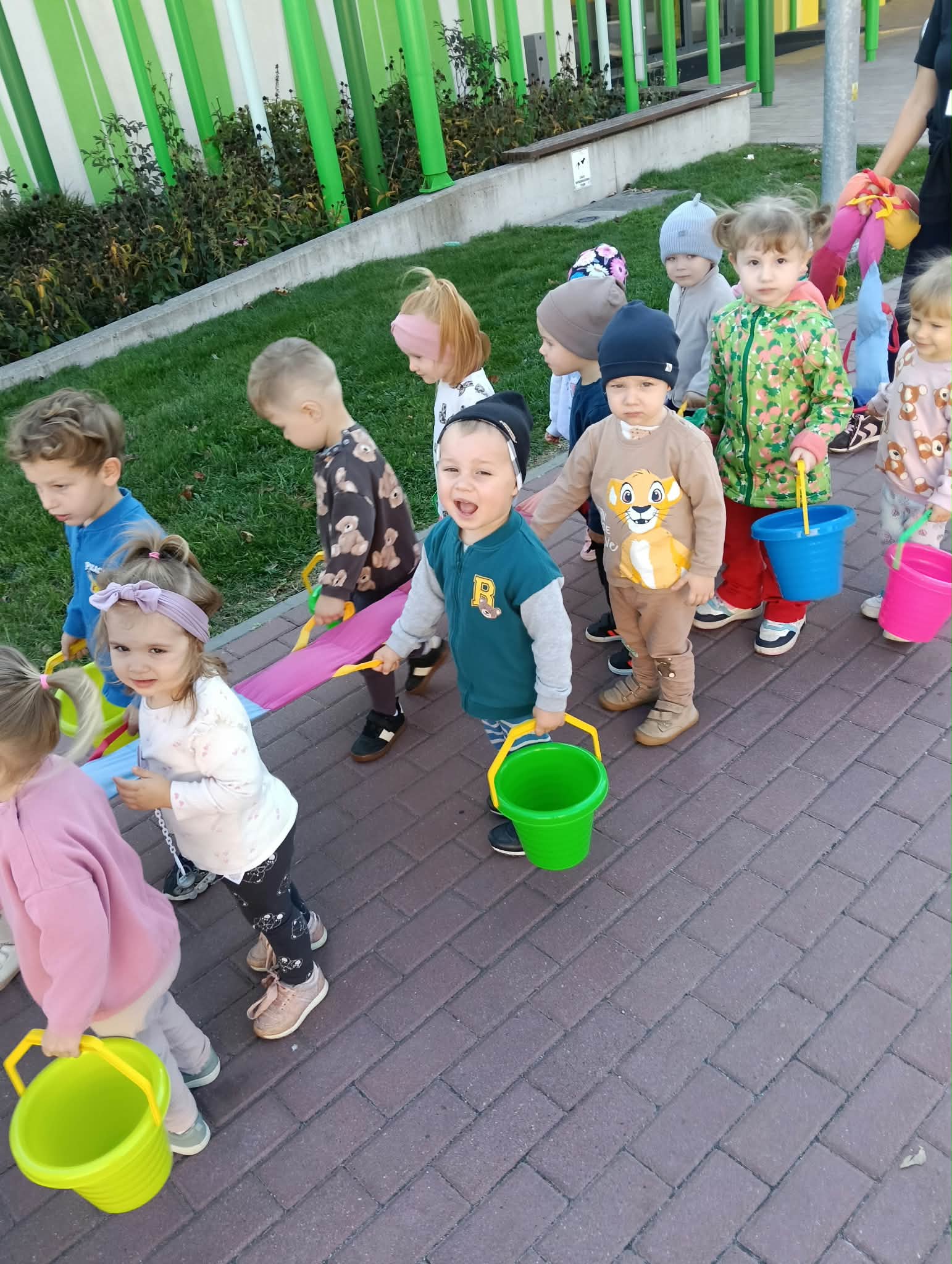 Zdjęcie przedstawia dzieci podczas spaceru i szukania darów jesieni